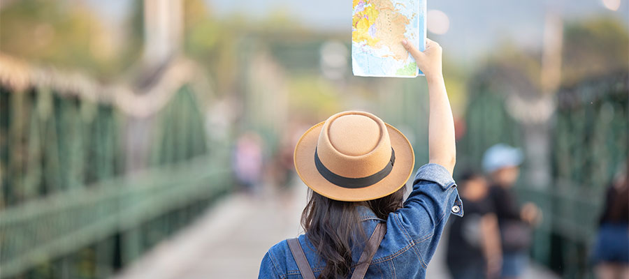 una mujer turistas en mano tiene un mapa de viaje.